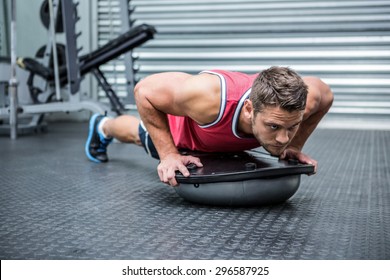 Muscular Man Using Bosu Ball In Crossfit Gym