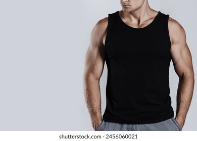 Muscular man wearing black tank top with blank space, ideal for a mockup.

 - Powered by Shutterstock