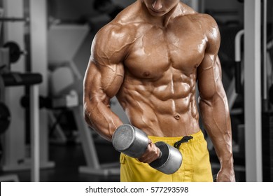 Muscular man working out in gym doing exercises, strong male naked torso abs