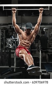 Muscular Man Working Out In Gym, Doing Stomach Exercises On A Horizontal Bar, Strong Male Naked Torso Abs