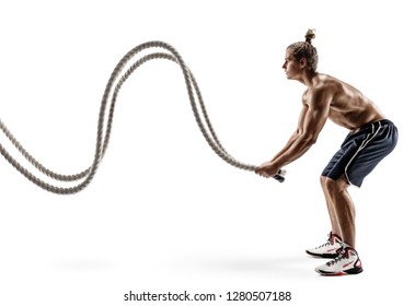 Muscular man working out with heavy ropes. Photo of sporty man with naked torso isolated on white background. Strength and motivation. Side view. Full length