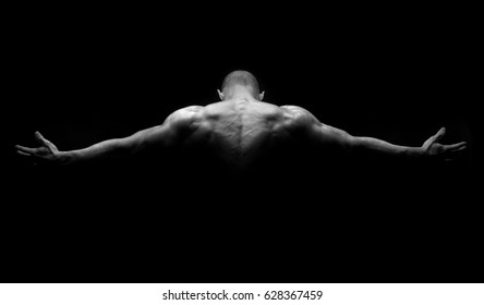 Muscular man's back in a dark background - Shutterstock ID 628367459