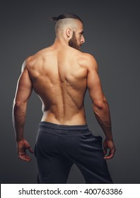 Muscular Man's Back On A Grey Background.