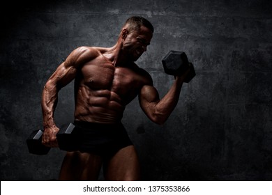 Muscular Men Exercise With Weights. He is performing biceps curls with dumbbels and barbell - Shutterstock ID 1375353866