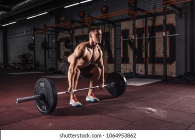 Muscular men lifting deadlift in the crossfit gym