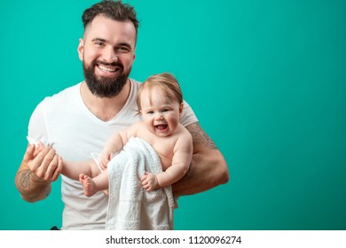 Muscular Middle Aged Happy Father Holding Cute Infant Adorable Baby Of One Year Old In Diaper. Studio Shot Over Blue Background With Blank Space.