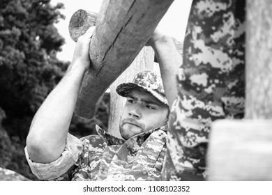 Muscular military man in military fatigues at bootcamp trains on obsticle course - Powered by Shutterstock