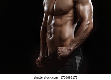 Muscular Model Sports Young Man On Dark Background. Fashion Portrait Of Strong Brutal Guy. Sexy Torso. Male Flexing His Muscles. Sport Workout Bodybuilding Concept.