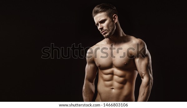 暗い背景に筋肉モデルのスポーツの若い男性 現代的な流行の髪型をした強い残忍な男のファッションポートレート セクシーな胴 男が筋肉を曲げている の写真素材 今すぐ編集