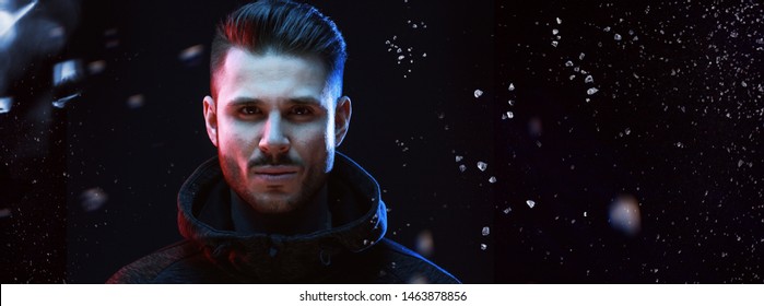 Muscular Model Young Man With Beard In Hoody On Dark Background. Fashion Portrait Of Brutal Sexy Strong Guy With Modern Trendy Hairstyle And Brown Eyes.