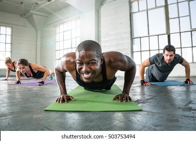 Muscular personal trainer instructor in workout with class endurance determination vigor - Powered by Shutterstock