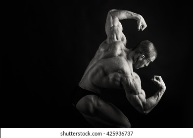 Muscular, Relief Bodybuilder On A Black Background