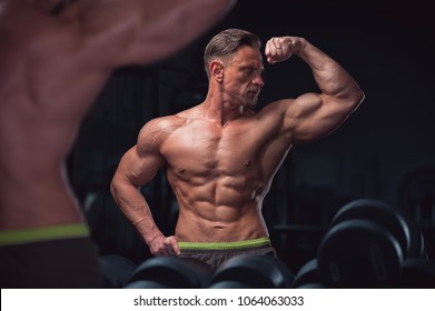 Muscular Sexy Fitness Model Posing Shirtless On The Background Of Gym Equipment. Mature Man Showing Perfect Relief Body.