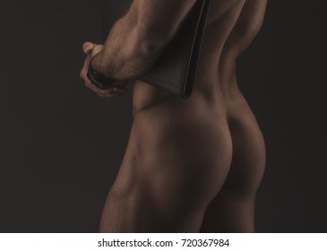 The muscular sexy naked businessman with folder, closeup male ass