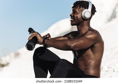 Water bottle, tired black man in gym and resting after fitness