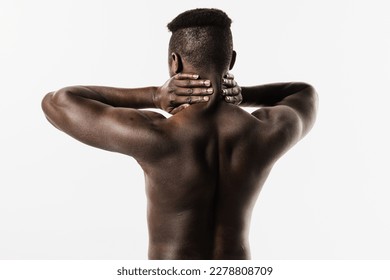 Muscular shirtless african man feel spine and neck pain because of spinal nerves compression on white background. Cervical spine osteochondrosis is radicular syndromes of african american man - Shutterstock ID 2278808709