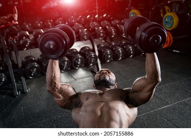 Muscular shirtless man working out with heavy barbells. Handsome bodybuilder with perfect abs? shoulders.