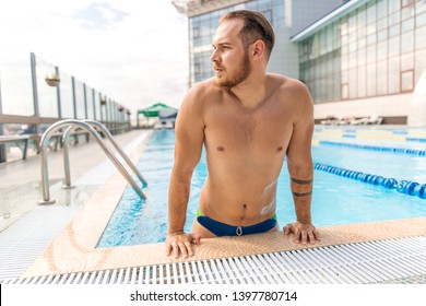 Muscular Swimmer Emerging From Outdoor Pool