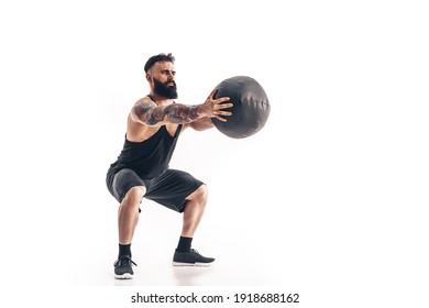 Muscular Tattooed Bearded Male Exercising Fitness Weights Medicine Ball In Studio Isolated On White Background.