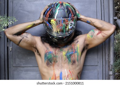 Muscular unrecognizable motorcycle rider with artsy body paint 