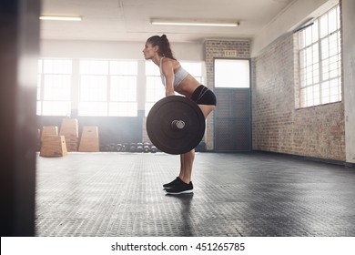 Muscular Woman In A Gym Doing Heavy Weight Exercises. Young Woman Doing Weight Lifting At Health Club.