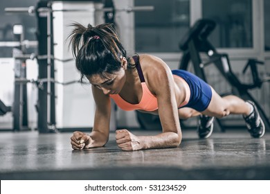 Muscular woman on a plank position.