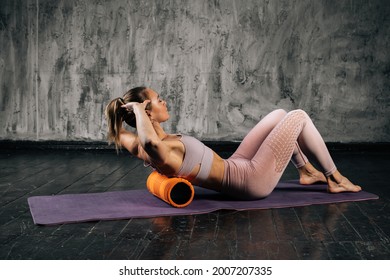Muscular young athletic woman with perfect beautiful body in sportswear using foam roller massager on upper back lying on yoga mat. Caucasian fitness female posing in studio with dark grey background. - Powered by Shutterstock