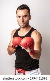 A Muscular Young Man Practicing Kickboxing On White Background