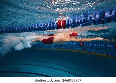 Muscular young man, swimmer in motion, preparing for competition, training in swimming pool indoors. Speed and technique. Concept of professional sport, health, endurance, strength, active lifestyle - Powered by Shutterstock