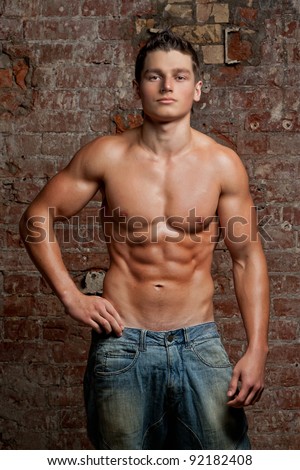 Muscular Young Naked Sexy Boy Posing In Blue Jeans On The Background Of A Brick Wall Muscular Young Naked Sexy Boy Posing In Blue Jeans On The Background Of A Brick Wall