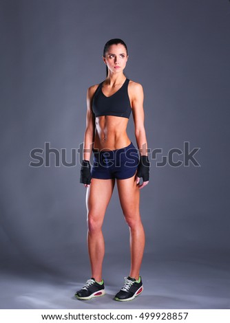 Similar – One young athletic woman at crossfit training, exercising with trx suspension fitness straps over dark background, front view, looking at camera