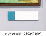 Museum art gallery painting artwork label author name picture photo description empty rectangle blank card plaque hanging on a wall object detail front view, frontal shot extreme closeup modern design