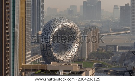 Museum of the Future exhibition space aerial timelapse during sunrise with iconic torus shape. Facade of stainless steel and windows that form an Arabic poem