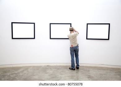 a Museum worker arranging frames on the wall