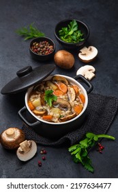 Mushroom And Barley Soup In Pot And Ingredients On Black Table