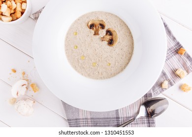 Mushroom Cream Soup In Bowl Top Down Flatlay View. Creamy Dinner Food With Croutons In White Plate. Organic Cooked Vegetarian Appetizing Meal For Lunch Horizontal Flat Lay On Wooden Table