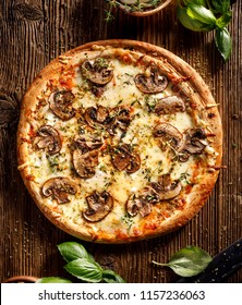 Mushroom Pizza With Addition Mozzarella Cheese And Herbs On A Wooden Table, Top View