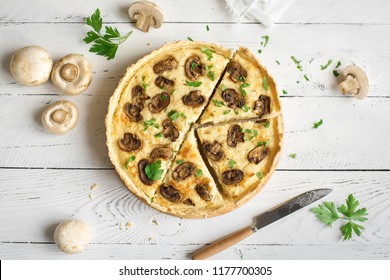 Mushroom Quiche Pie  with champignons and cheese on white wooden background, top view. Savory tart with mushrooms.