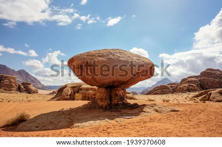 Mushroom shaped rock at Wadi Rum desert, bright sun shines on mountains background