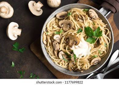 Mushroom Spaghetti Pasta And Cream Sauce On Rustic Background, Top View. Homemade Italian Pasta With Champignon Mushroom In Cooking Pan.