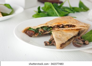 Mushroom Spinach Quesadilla Cut Into Pieces And Arranged On White Plate, Overhead Shot, Vertical Image