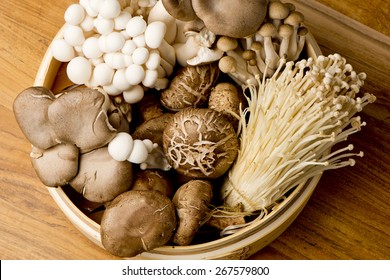 Mushrooms. Fresh Organic, enoki, shiitaki, hen of the woods, baby portabello, button mushrooms in wooden woven basket at a restaurant. Variety of Mushrooms in a basket, closeup and shot overhead. - Powered by Shutterstock