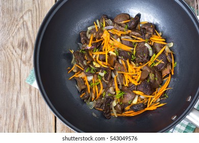 Mushrooms Fried With Onions And Carrots In The Wok. Studio Photo