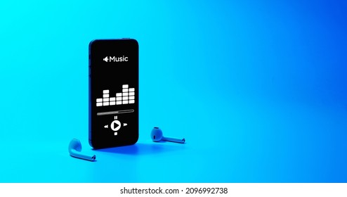 Music background. Mobile smartphone screen with music application, sound headphones. Audio voice with radio beats on blue gradient. Recording studio or podcasting banner with copy space