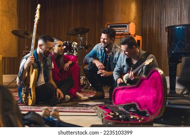 Music band members sitting on the floor in a rehearsal studio. High quality photo - Powered by Shutterstock