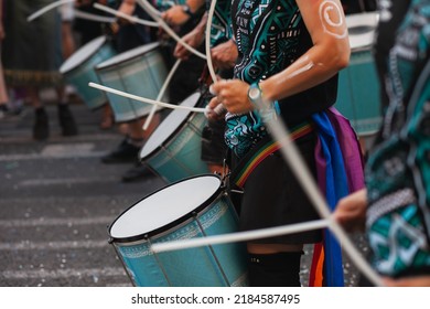 Music band playing drums in the street at public event. Drummers musicians playing music at Pride festival in June. Pride month march celebration. Queer lgbt community awareness.