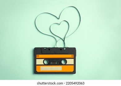 Music cassette and hearts made with tape on turquoise background, top view. Listening love song