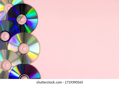 Music cd's dvd's flat lay on pink background top view with copy space. Creative design 80-s style. Recording and listening music, radio, dj concept. Web banner template. Stock photo.