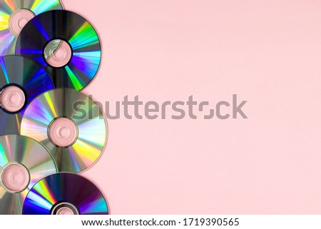Music cd's dvd's flat lay on pink background top view with copy space. Creative design 80-s style. Recording and listening music, radio, dj concept. Web banner template. Stock photo.