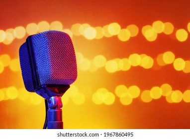 Music concept background with a vintage microphone in front of flashing lights. A template with copy space for text